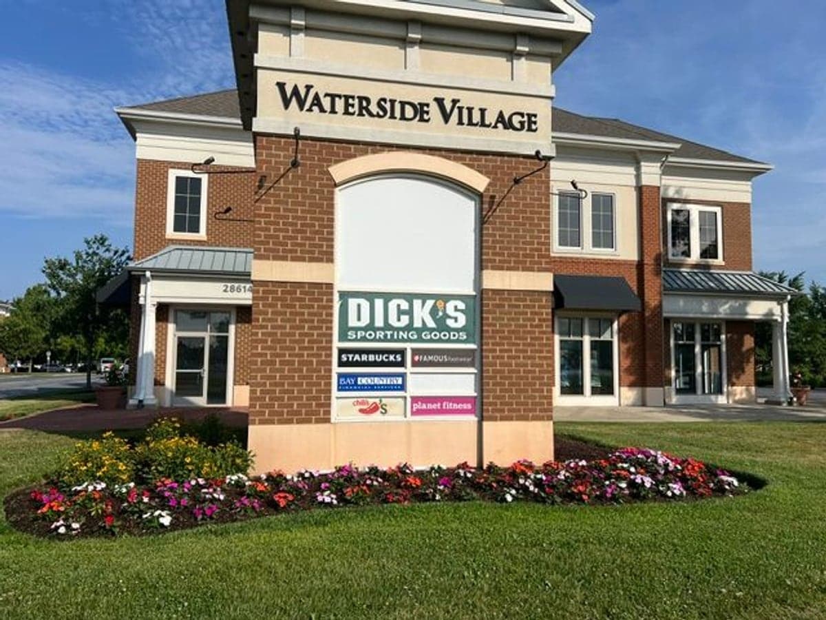 Colorful seasonal flower beds and a manicured lawn at the Waterside Village shopping center